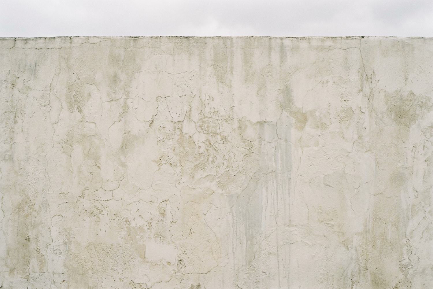 A plain wall of weathered render in even light.