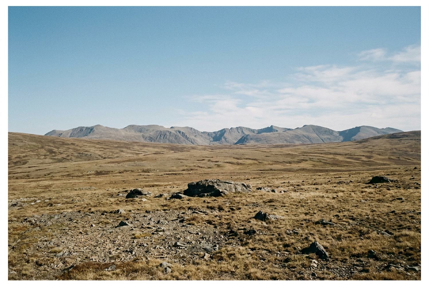 A wide bare upland plain under a hard blue sky.